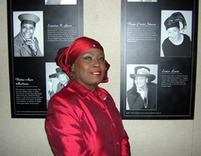 Peggy Bertram in front of panel exhibit at Studio Arena Theatre